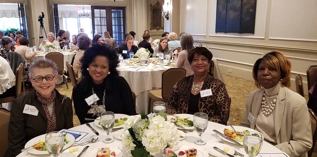 Women sitting at a round dining table at an event